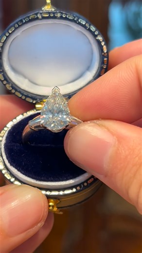 A vintage 1950s engagement ring featuring a 2.10 carat pear cut natural diamond at center, flanked by two baguette cut diamonds that total an additional 0.16 carats. Shop online at brackenjewelers.com or visit our studio in Santa Monica by appointment. This ring is timeless in its classic three-stone platinum design, and unique with its mixed cut diamonds. Would you keep it bright and white with a platinum diamond eternity band? Go eclectic and pair it with our “City of Six” 20K California Gold 