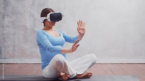 Young pregnant woman in VR helmet. She is preparing for the birth of a child on a virtual simulator. Augmented reality technology concept.