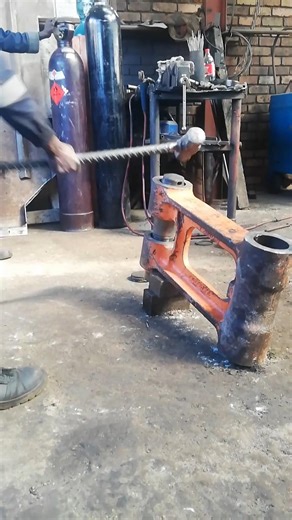 SWINGING AND LANDING HAMMER TO PUSH OUT DAMAGED BRASS SLEEVE FROM EXCAVATOR'S END BOSS IN WORKSHOP