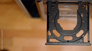 Insert and eject a blank cd/dvd in a player/recorder. View from above.