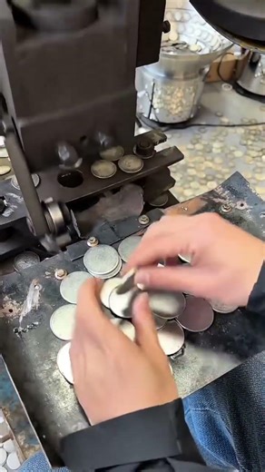 Hand Feeding Metal Blanks into a Precision Coin Stamping Machine