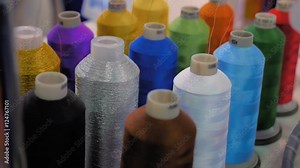 Rows spools of thread of different colors in the industrial sewing machine