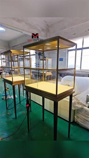 光影奢境｜高脚展柜，盛放每一寸璀璨 几何方正轮廓，暖金金属框架细腻温润，不浮夸只高级✨加厚柜脚稳重大气，超白玻璃打造沉浸式观赏视角。极简轻奢，适配多类装修风格。源头工厂精工定制，每一处细节都是高端商用陈列的品质宣言💎Luxurious Realm of Light & Shadow | Tall Display Case, Showcasing Every Inch of Brillia