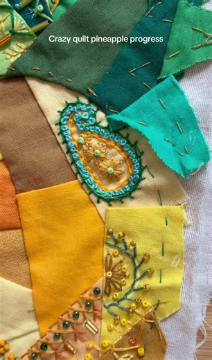 Progress on the crazy quilt patchwork pineapple with embroidery and beading. Feather stitch, blanket stitch, lazy daisy stitch, French knot, wheat stitch, chain stitch, herringbone stitch, straight stitch. Greens, yellows, brown. Seed beads, bugle beads. Small sewing project, work in progress, hand sewing. #crazyquilt #patchwork #embroidery #handsewn #smallsewingproject