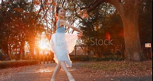 Nature, dancing and ballet woman in a park practicing for a concert, show or classical theater. Art, elegant and Japanese female ballerina in rehearsal with music at outdoor garden or field in Autumn