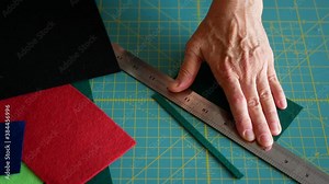 Cutting felt, Woman cuts a red felt using a rotary cutter and a cutting mat Stock Video
