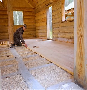Creating a warm wood floor using sawdust in a log cabin life video. | Alex Zana