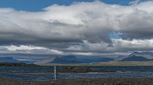 Time lapse of Clouds move over the mountains and bay in Iceland.