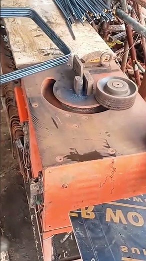 bending long steel bars with a professional machine to create rectangular frames for construction