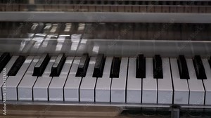 Piano or Grand Piano Playing Itself. Performing a musical composition on a piano that plays by itself. Self-Playing. White, black piano keys press independently without human intervention. Close up.