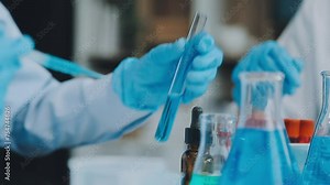 Health care researchers working in life science laboratory. Young female research scientist and senior male supervisor preparing and analyzing microscope slides in research lab.