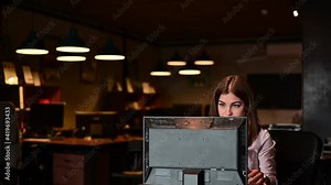 Nervous breakdown at work. Business woman freaks out and breaks the computer in the office