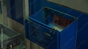 We can see a blue machine. Liquid is falling down in a machine and we can see water dripping.