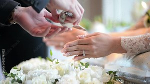 Hands pouring blessing water into groom and bride's bands, Thai wedding
