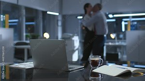 Blurred shot of colleagues hugging and making out late in empty office