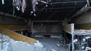 A haunting and eerie view of a derelict building characterized by its exposed, crumbling walls and scattered debris