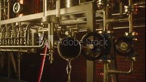Vodka pouring from big tubes inside professional alcohol production factory . Process of distillation . Camera moving inside pipe . Close up slow motion . Shot on ARRI ALEXA Camera with Laowa lens