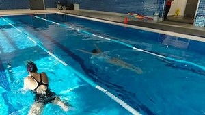 clip-1024397978-two-young-women-exercising-pool-drone-footage