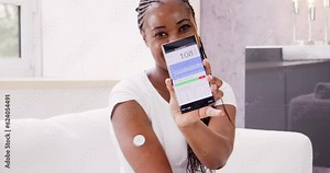 Woman Testing Glucose Level With Continuous Glucose Monitor