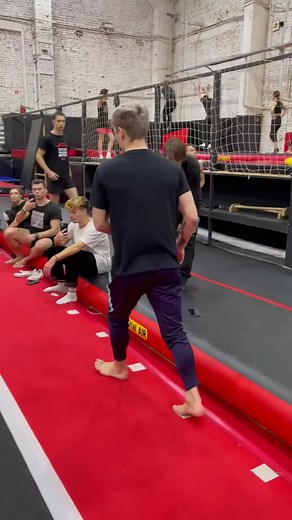 Acrobatic Trampoline Jumps by Young Man in Gym