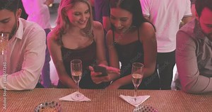 Party, cellphone and girl friends with champagne at a luxury, elegant and classy celebration or event. Smile, phone and young women talking with a glass of sparkling wine at nightclub together.