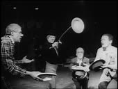 B/W 1955 clown spinning dish on stick as other clowns try to catch it...