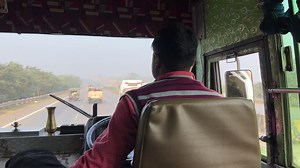 Back view of Bus driver driving by handling steering wheel. Highway driving. | Premium Stock Video Footage