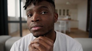 Close up sad upset African American man lonely ethnic male guy homeowner face expression frustrated alone at home sorrowful tired health problem crisis trouble worried think pensive looking at camera