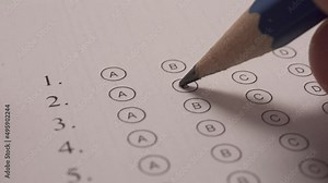 Student Hand Filling Out In Answer Sheet Using Pencil. Close Up