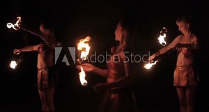 Fire show performance. Group of hot women – female fire performers dance gathering up burning fire torches on black background. Slow motion Stock Video