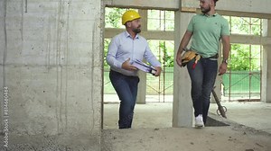 A building inspector and a construction manager discuss and check the progress of a construction site, ensuring everything meets regulations and plans. Stock Video