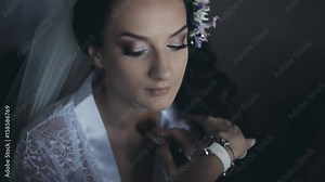 Portrait of bride talking on smartphone while the make-up artist preparing the woman to wedding ceremony, using brush.