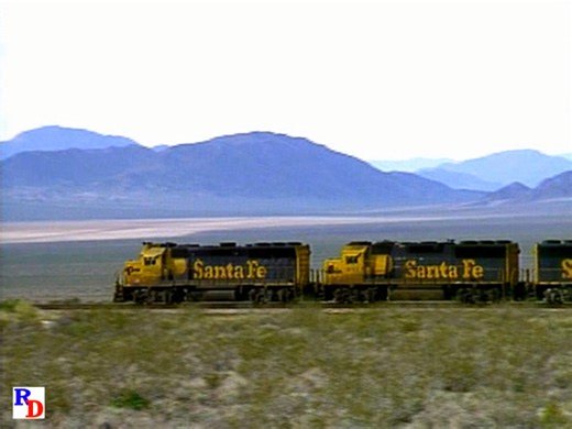 A westbound Santa Fe train rolls down Ash Hill in the Mojave Desert and meets and eastbound train. From the Pentrex show "Santa Fe’s Mojave Mainline" https://rfd.video/SFMojave | Railfan Depot
