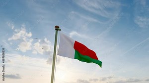Flag of Madagascar waving in the wind, sky and sun background. Madagascar Flag Video. Realistic Animation, 4K UHD.