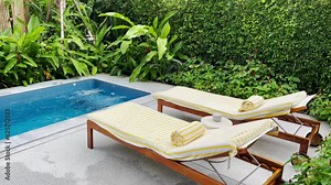 Pool chairs have a water circulation system in a private garden with green trees in the background. rest and relax.