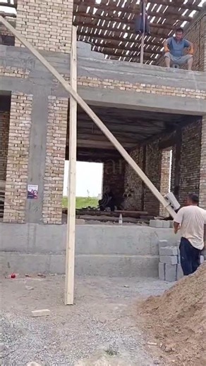 Brick Block Transfer via Wooden Pole at Construction Site