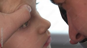 A close-up demonstration video of an expert doctor examining eyesight of a young female patient by using ophthalmoscope. Professional ophthalmological equipment usage. Vision testing concept.