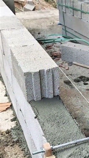 building a concrete block wall using mortar and alignment tools for precise leveling and placement