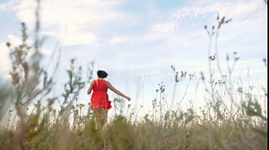 Plus size fashion model in slow motion video walking on the grass. fat woman on nature in the field grass flowers summer. lifestyle overweight female body. full girl length portrait nature freedom of