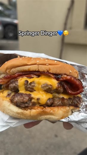12 reactions | Springer Dinger is a double beef patty cheeseburger with bacon, cheese, caramlized onions and bbq sauce.肋燎 #burger #cheeseburger #canadiana #torontofood #toronto #bluejays #springer #viral #fyp | Canadiana Grill By The Lake | Facebook