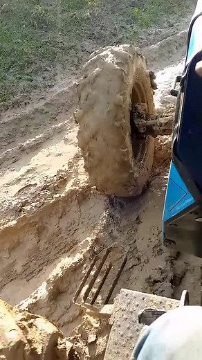 Close-Up of a Blue Tractor Wheel in Muddy Terrain