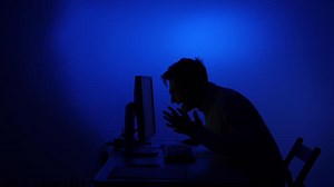 Man experiencing computer frustration and work technology stress