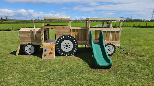 Our wooden tractor and trailer is ideal for toddlers in commercial playgrounds. Offers a slide, rock wall, block wall, net, ladder, tunnel, bridge and a steering wheel to drive it around. Lots of fun with imaginative and active play. | Active Garden