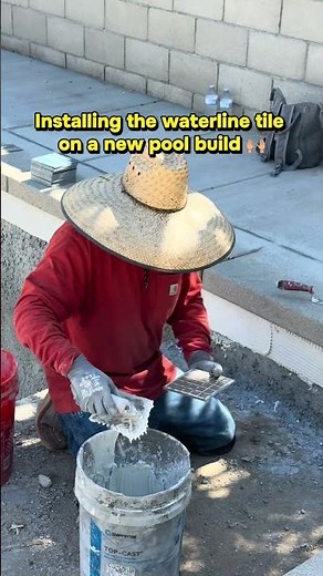 Installing the waterline tile on a new pool build