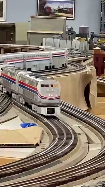 Three Amtrak Genesis power a 9 car Superliner trainset through the S-Curves on Lionel layout.