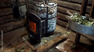 A traditional Russian sauna. Interior of a steam room. Wood-burning stove and oak brooms in bathhouse. 4K