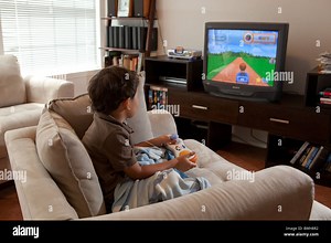 Four-year-old Mexican-American boy uses VTech V.Smile motion active learning console to play video game on TV screen in his den Stock Photo - Alamy