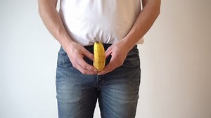 鼠径部にバナナを持つ男性。前立腺の問題。男性の親密な問題を熟成。ステロイドと力価。受動的生活様式