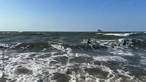 A child swims in the Sea of Azov. A boy jumps into the sea waves from the beach. The boy dives into the foaming wave. The delight of a child from a vacation at the sea. Happy moments with children. 4K