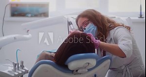 Dentist woman drills her patient tooth